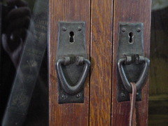 Close-up of hand-hammered iron pulls and quarter-sawn doors.